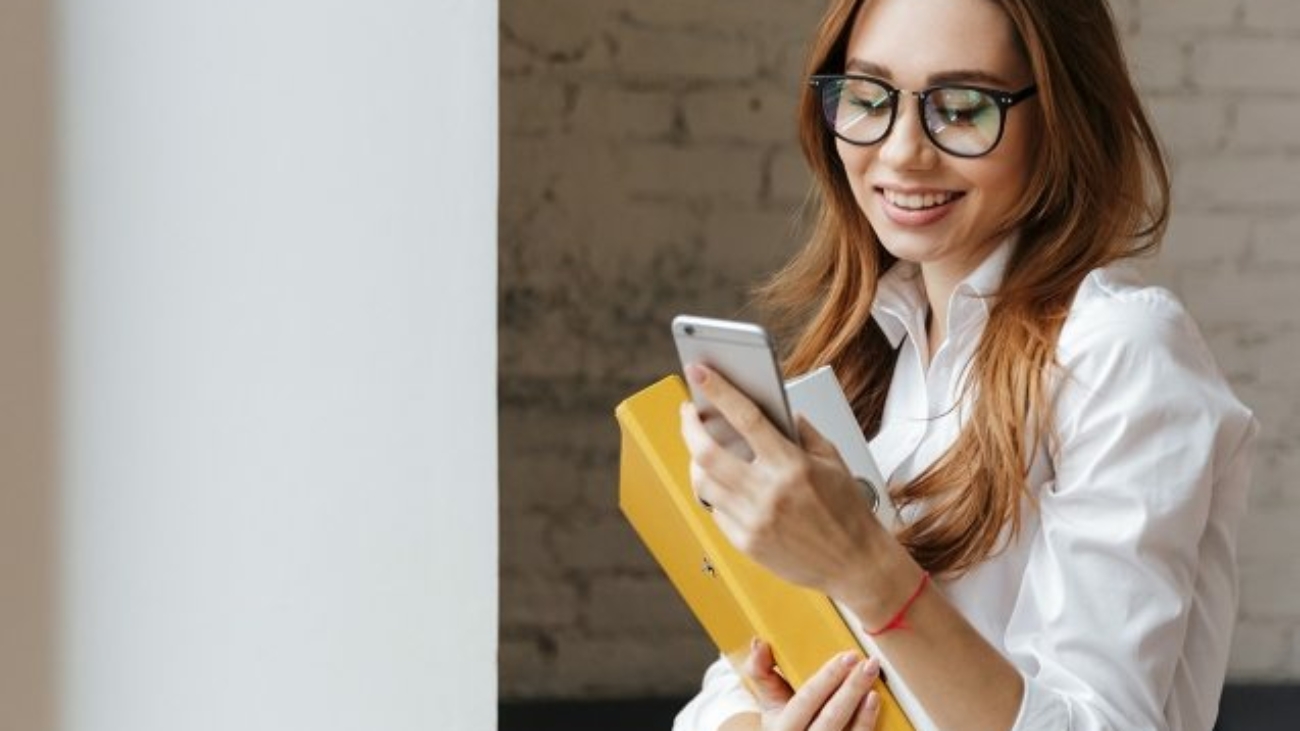 happy-business-woman-indoors-using-mobile-phone-P9WS3SD-637x478