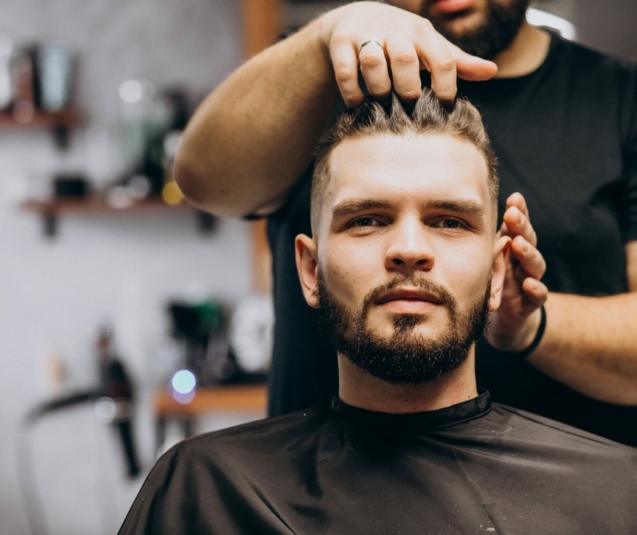 Hairdresser at a barber shop styling hair of a client
