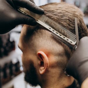 Client doing hair cut at a barber shop salon
