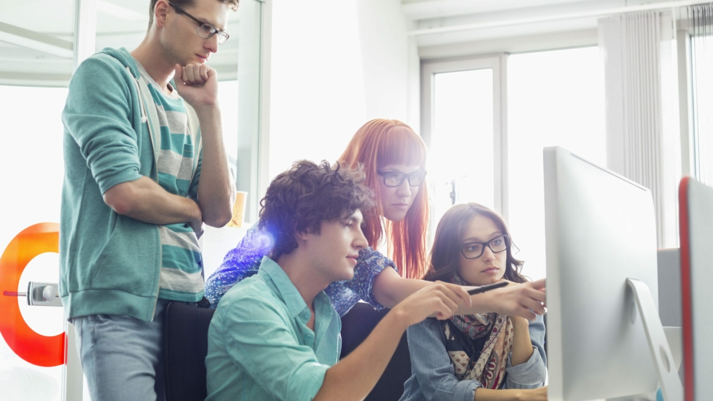 Creative business colleagues discussing over computer in office