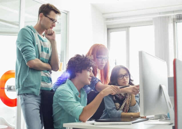 Creative business colleagues discussing over computer in office