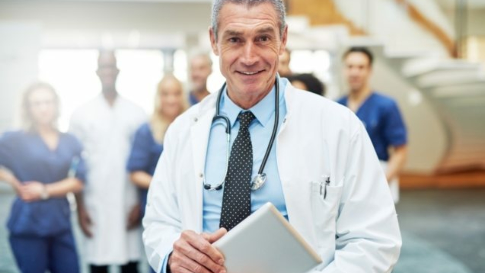 cheerful-mature-doctor-with-tablet-in-hospital-UW72G9C-637x429