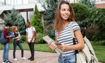 happy-woman-student-with-backpack-holding-books-PNFUGG71-370x222