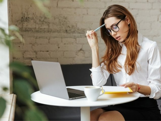 thoughtful-business-woman-indoors-using-laptop-P5HYUQX-637x478
