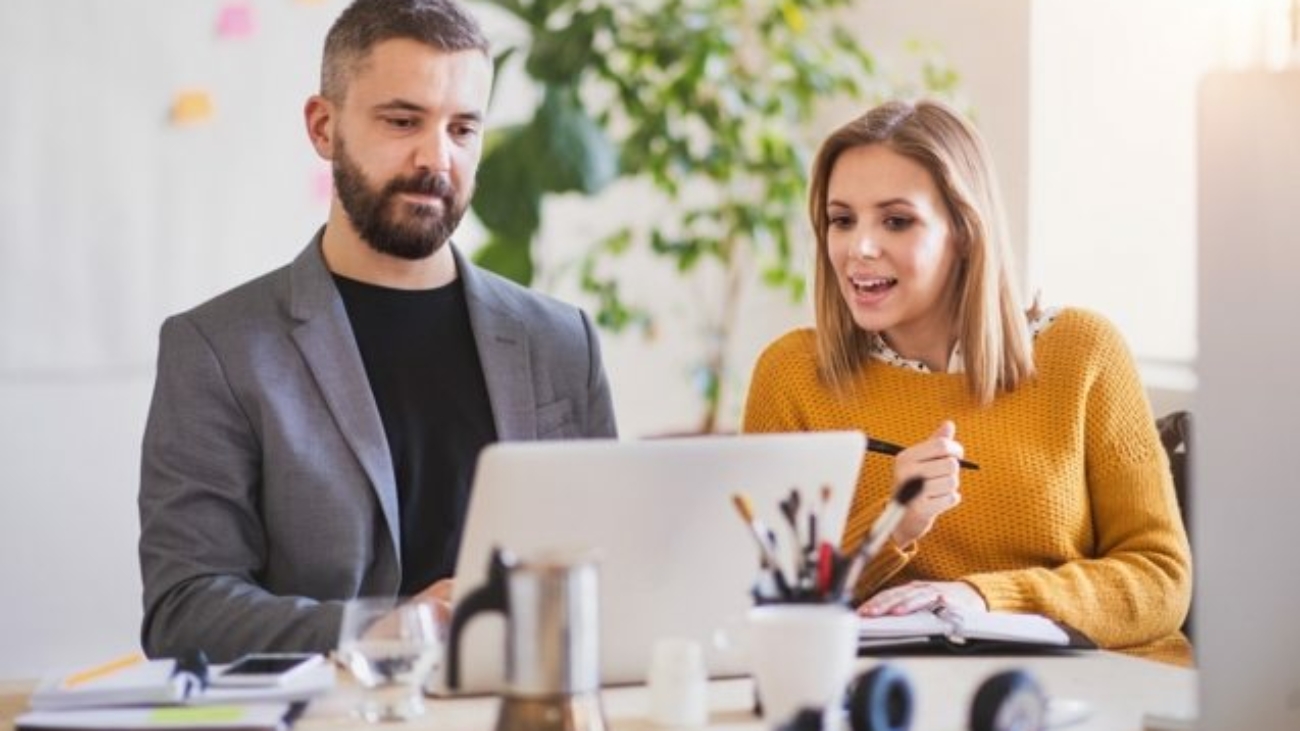 two-business-people-with-wheelchair-in-the-office-P7XLSBC-637x478
