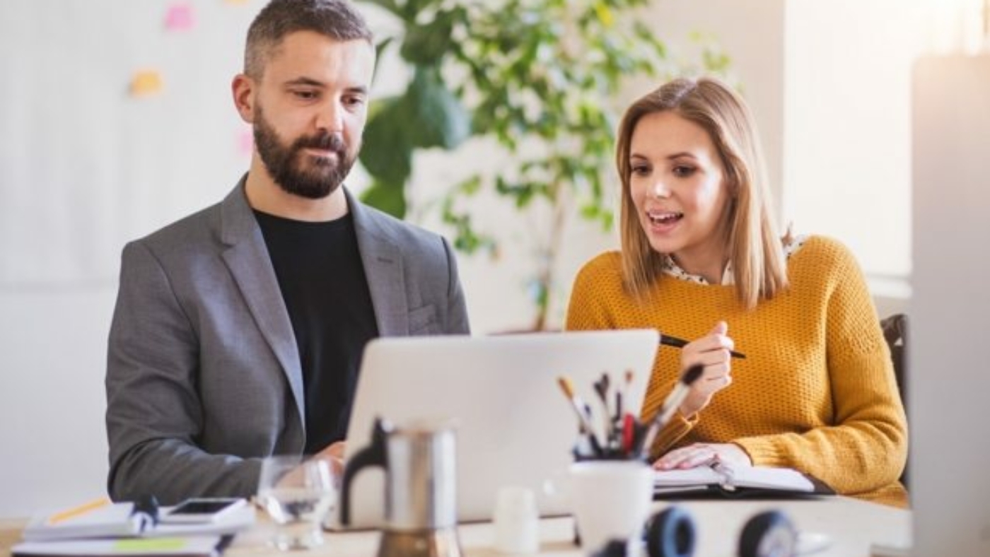 two-business-people-with-wheelchair-in-the-office-P7XLSBC-637x478