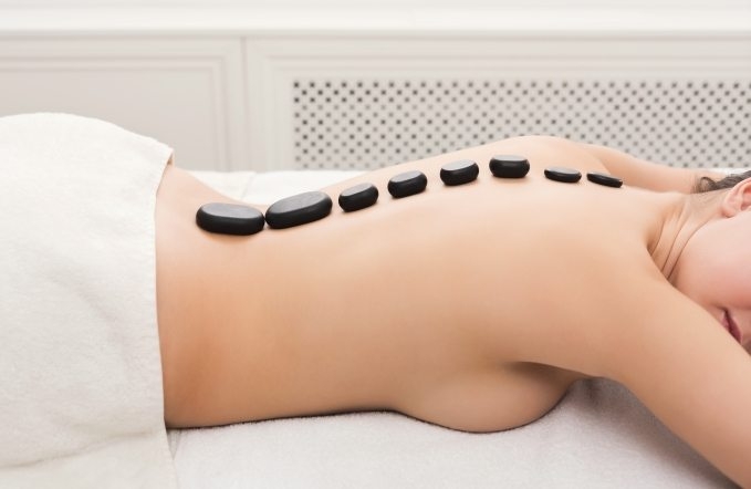 woman-getting-hot-stones-massage-at-spa-salon-5AVNW2T-679x442