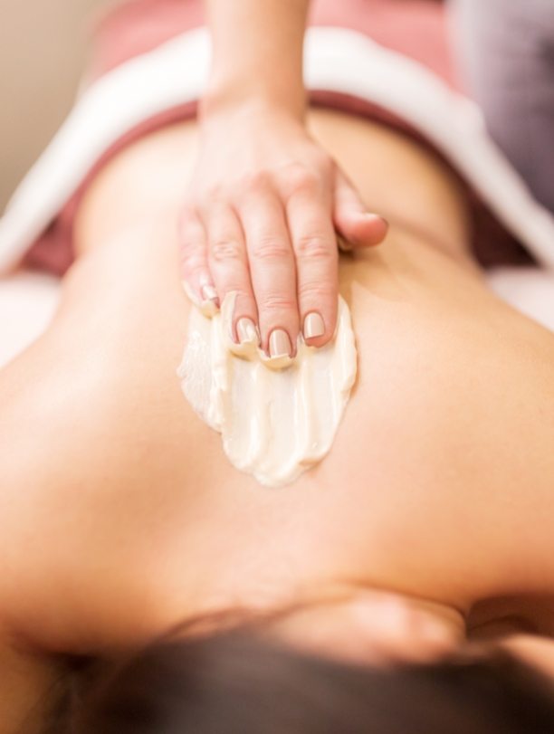 woman-having-back-massage-with-cream-at-spa-PFCWZ34-1